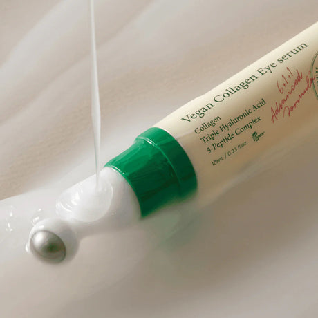 Image showing the Axis-Y Vegan Collagen Eye Serum tube with serum being poured on top of it. The serum is of a cloudy gel consistency. The tube has a metallic roller-ball applicator.